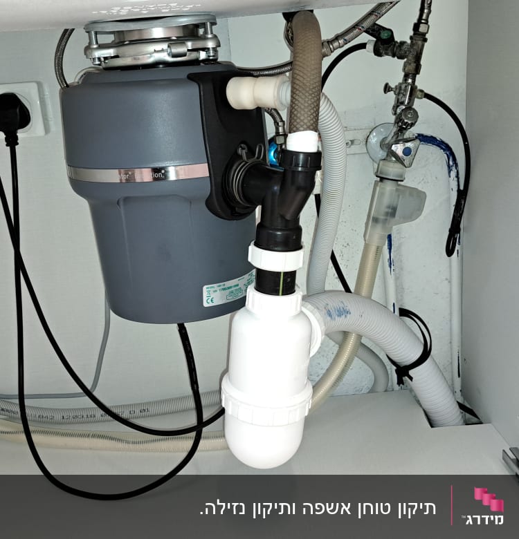 מערכת צינורות מתחת לכיור עם טוחן אשפה